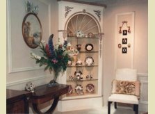 Painted corner display cabinet with delicate hand carved mouldings